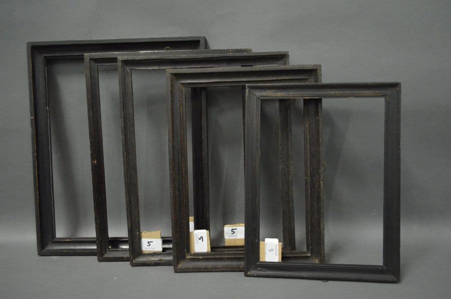 CINQ BAGUETTES en bois mouluré et noirci.…