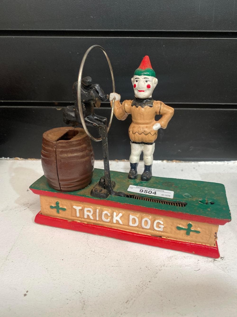 Cast iron trick dog money box, hand painted detail. 19cm L, 18cm H, 9cm D.