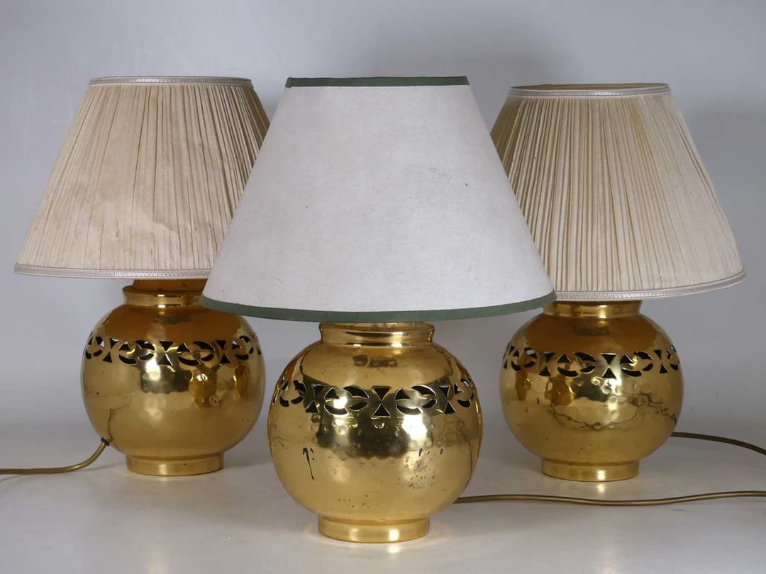 Lot 5 - A set of three hammered brass table lamps