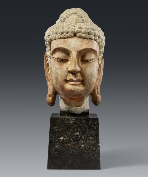 A marble head of a Buddha. In the style of the Tang period (618-907)
