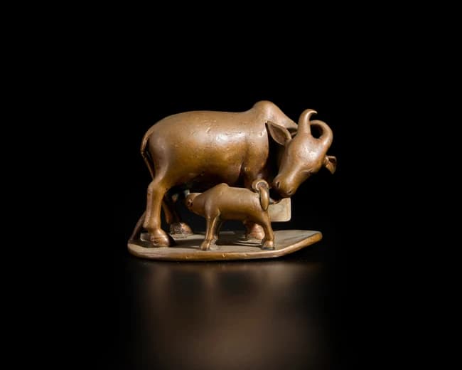 A bronze model of a cow and its calf