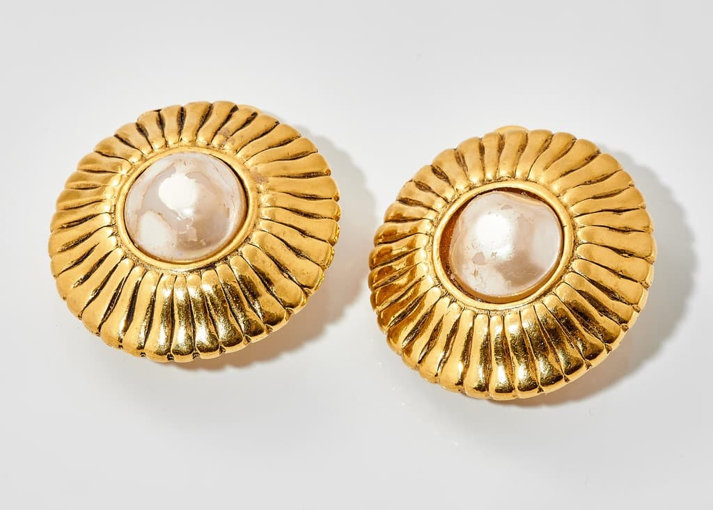 CHANEL. Paire de clips d'oreille en métal doré sertis de perles d'imitation.