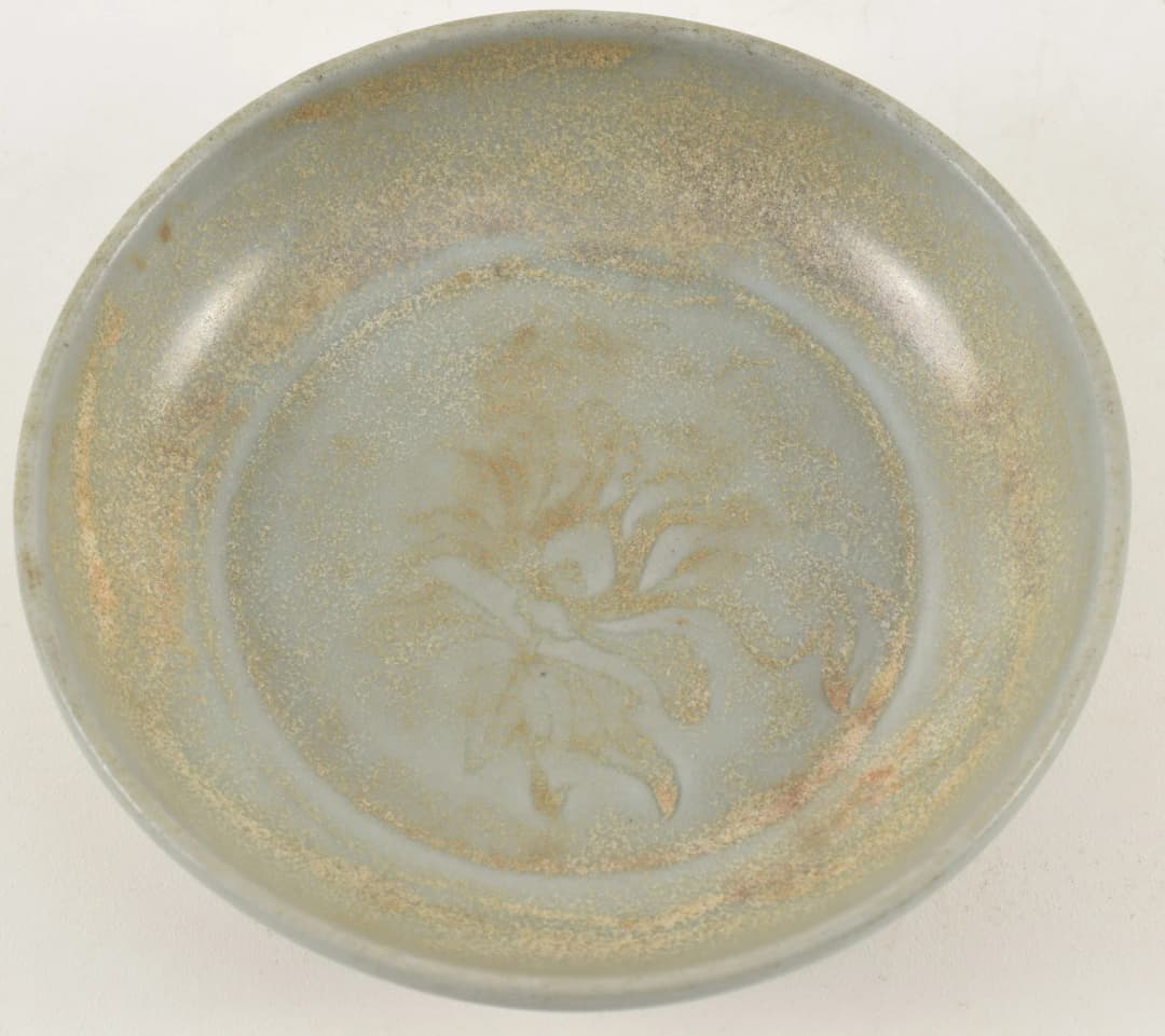 Early Chinese celadon dish with floral decoration, possibly Guan ware.