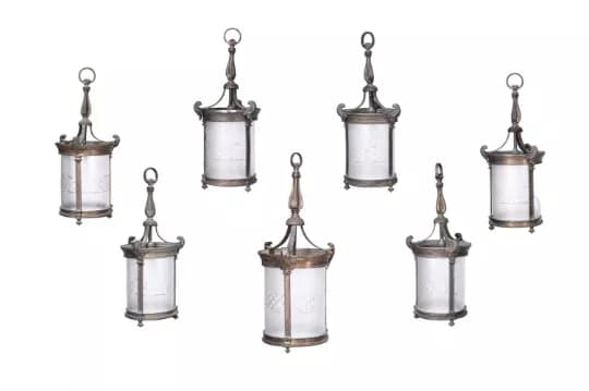 A SET OF SEVEN EDWARDIAN GILT BRONZE AND FROSTED GLASS HANGING LANTERNS