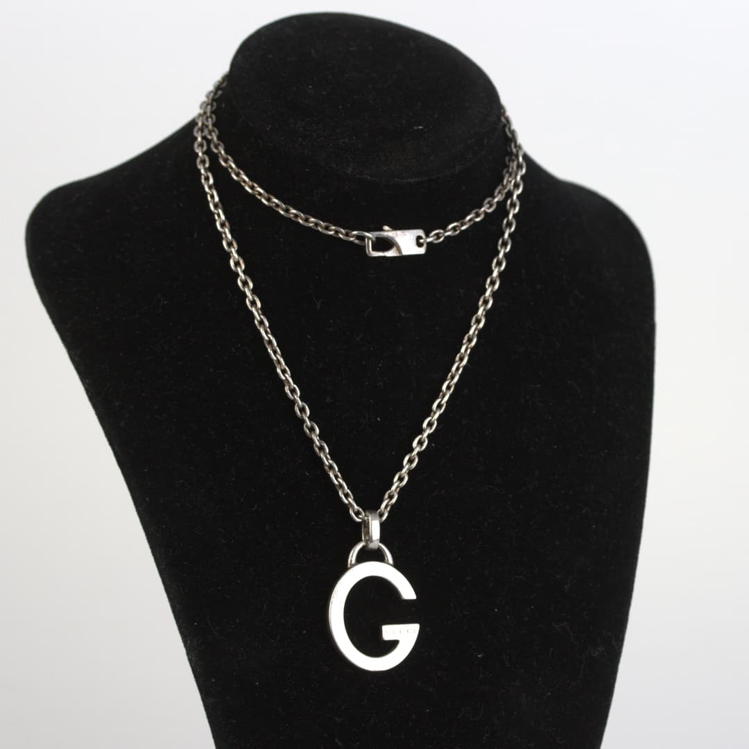 GUCCI. Halsband med monogramhänge G i silver, kedja ostämplad.