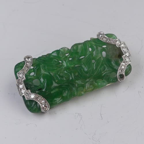 A carved jade Brooch, pierced with Fu dog and bird decoratio...