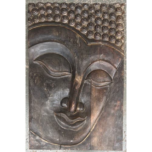 A large relief carved wall plaque depicting the face of Budd...