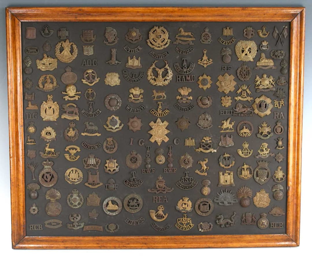 A large collection of early 20th century cap badges