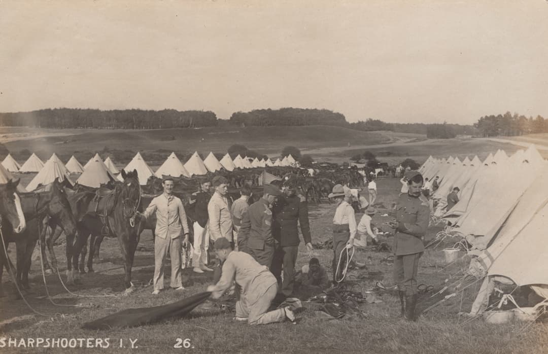 A collection of approximately 69 photographic postcards of military