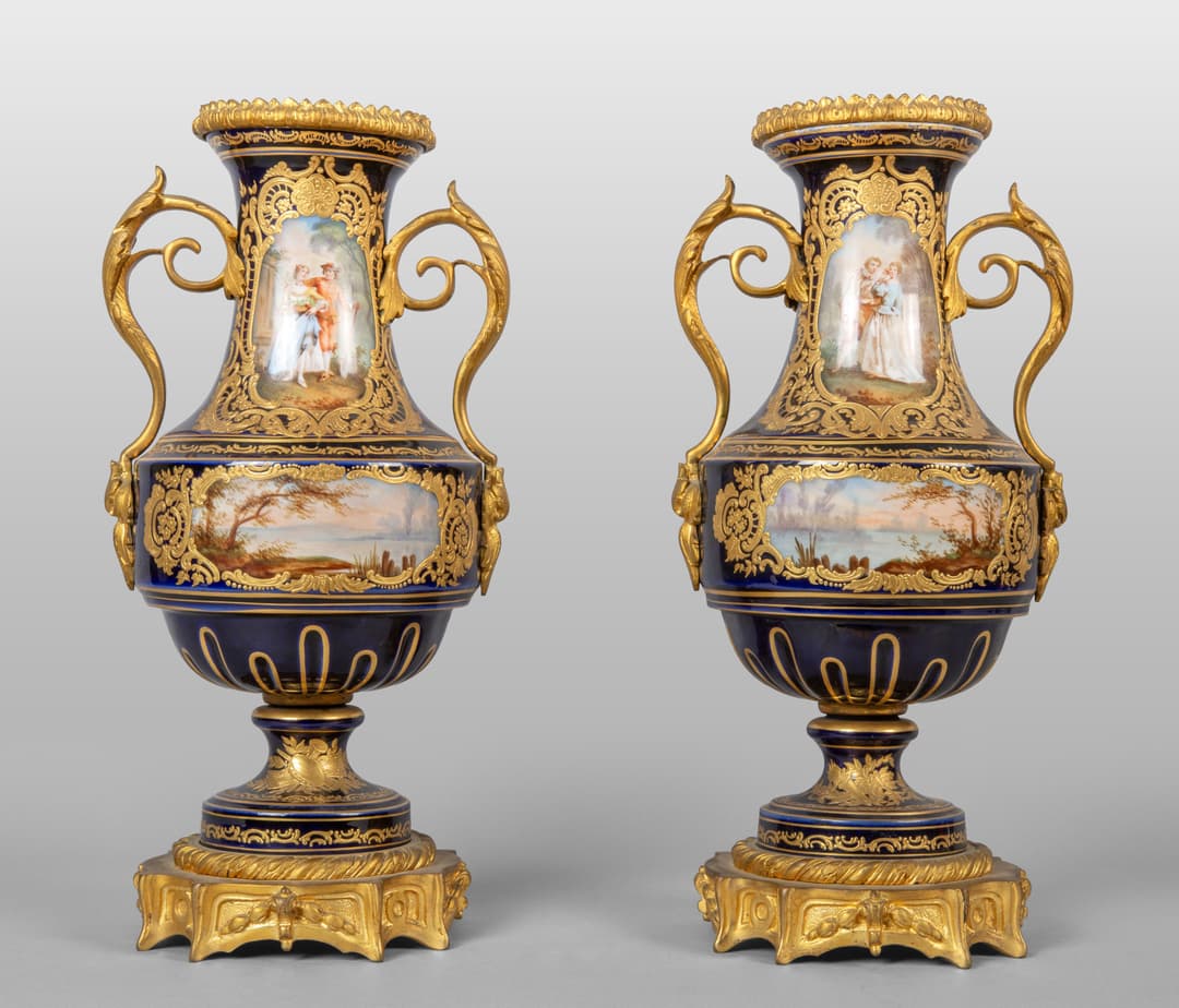 Coppia di vasi in porcellana blu e bronzo dorato decorati con paesaggi