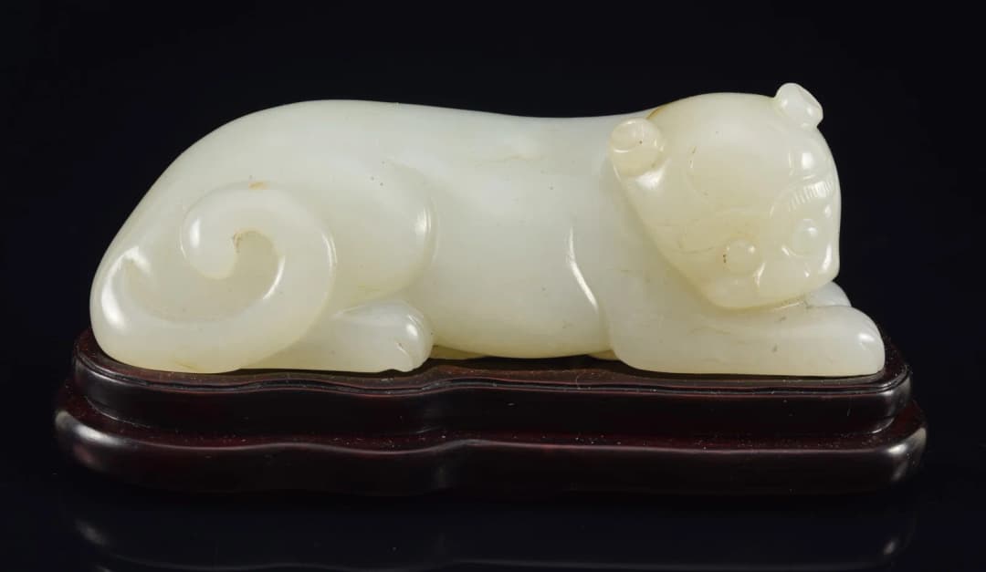 Jade tiger. Pure white color. China. 18th century. Fitted stand. 3.5in length.