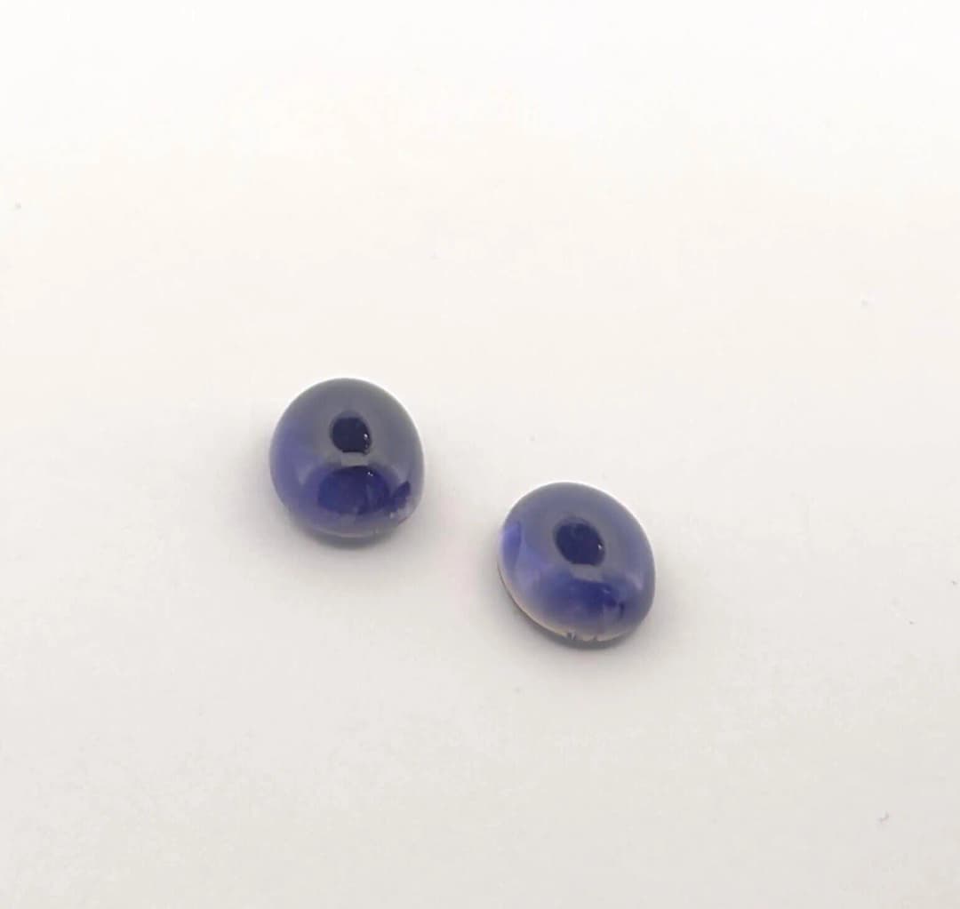 Pairing of two iolite cabochons on paper. Size: 10 x 8 mm. W - Lot 58