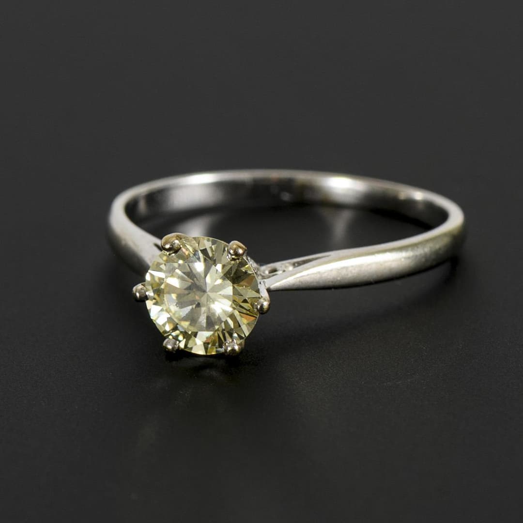 Ring with tinted diamond solitaire.